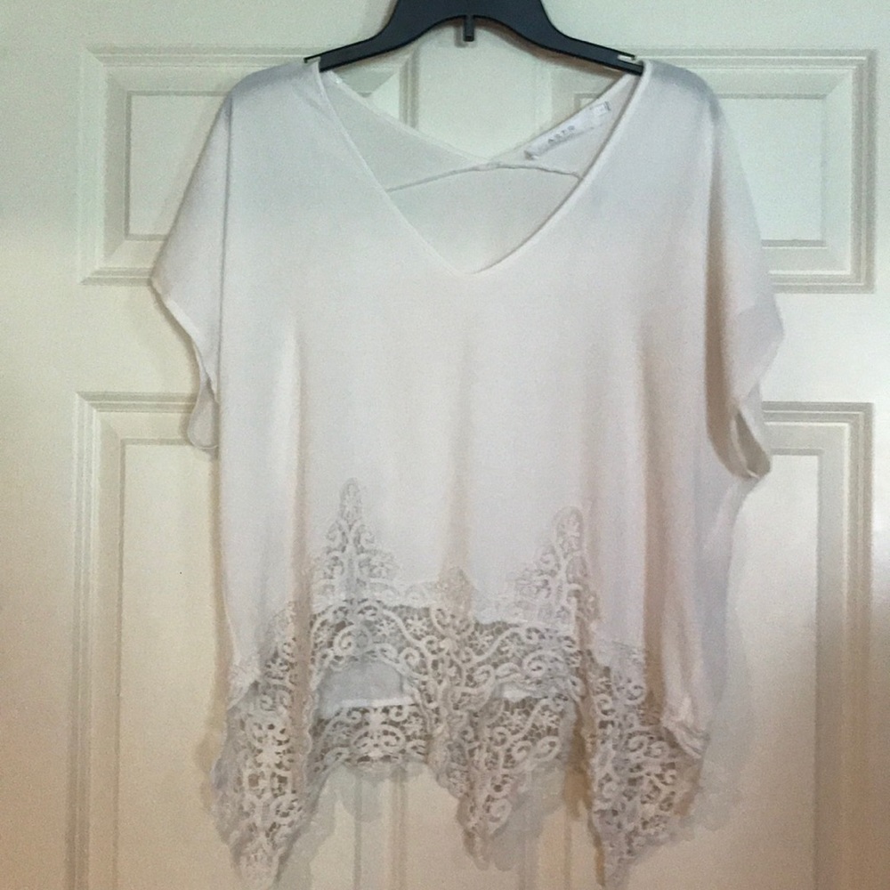 White flowy top with lace at the bottom.